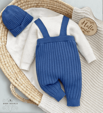 Custom baby name Newborn Knit Set featuring a cozy sweater, suspender pants, and beanie in a basket.